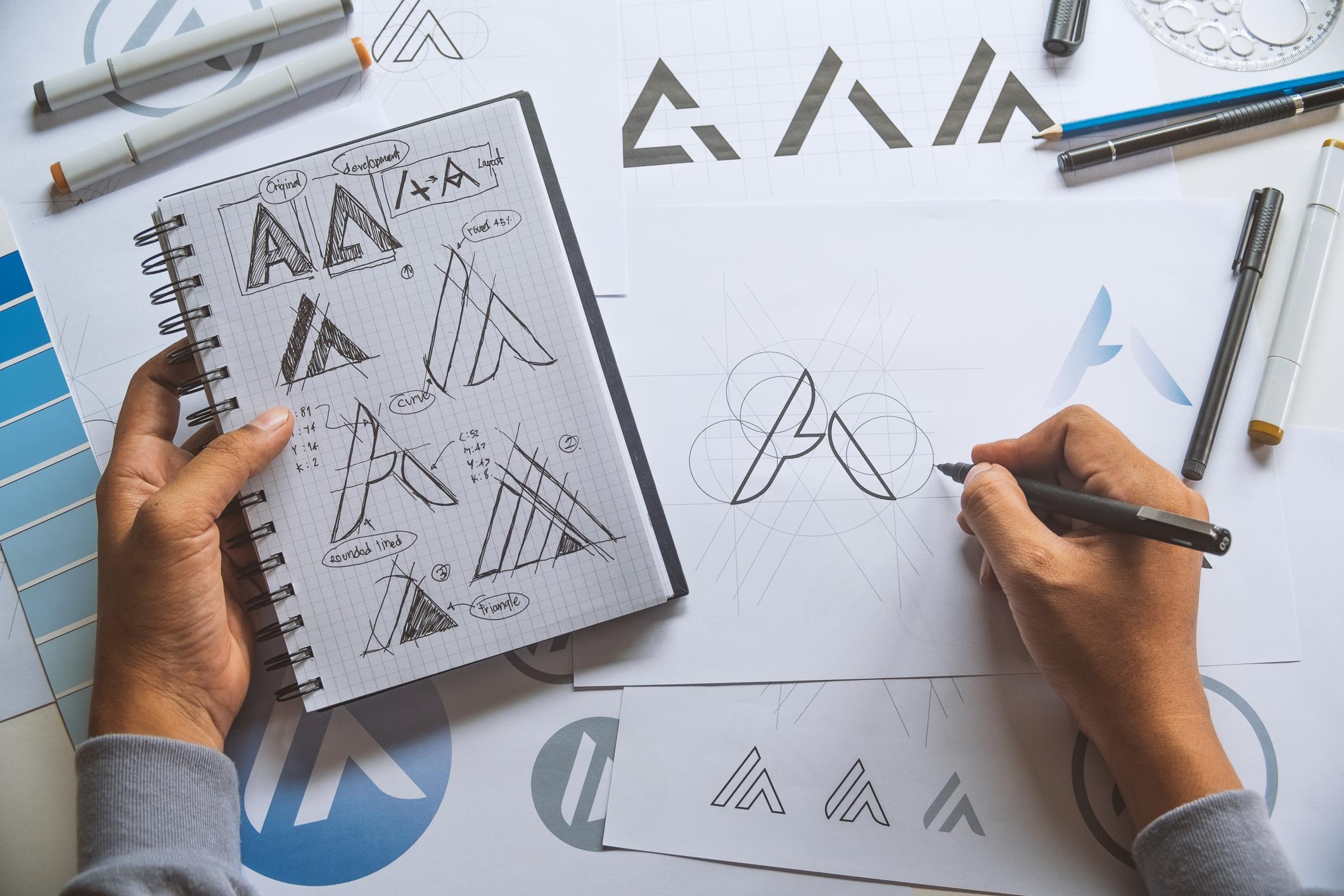 Overhead view of a professional designing a logo on paper