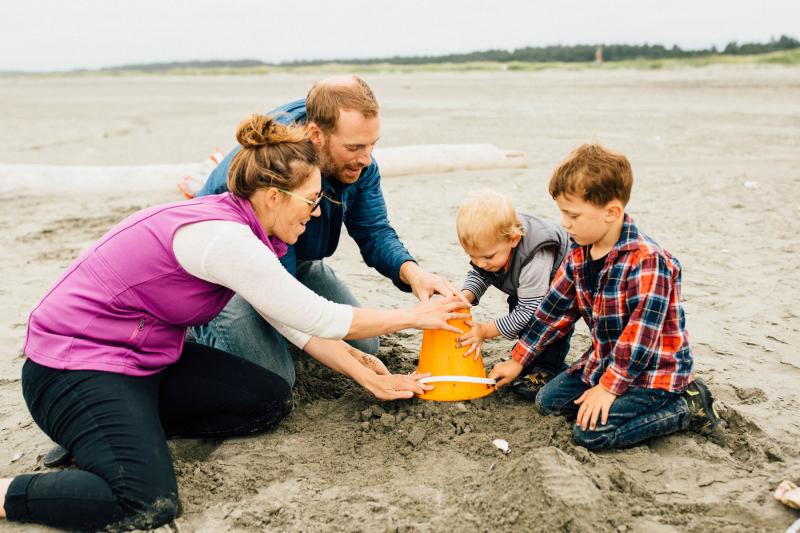 Young family playing in the sand at a Washington beach
