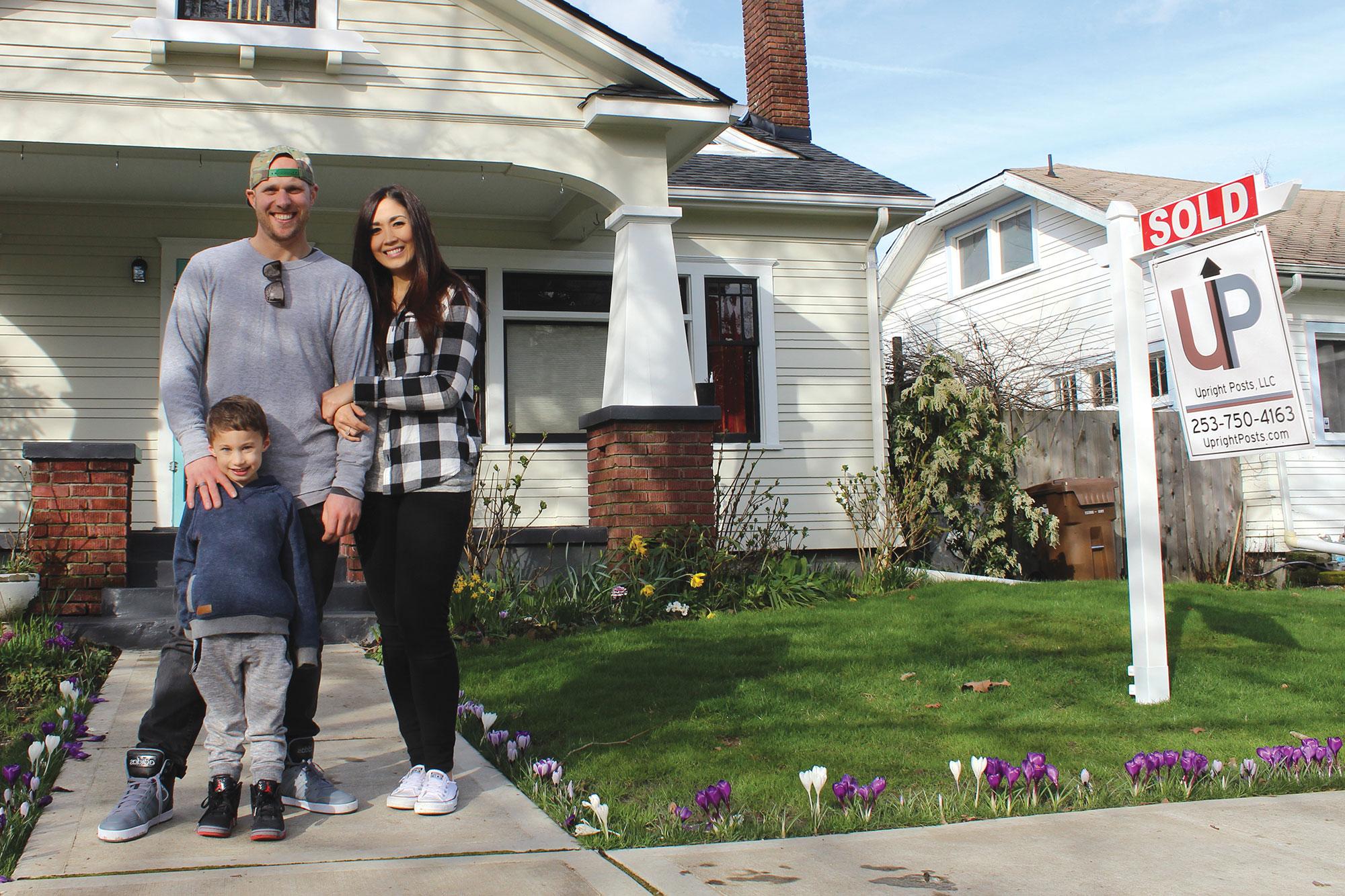 Family standing outside of a newly purchased home