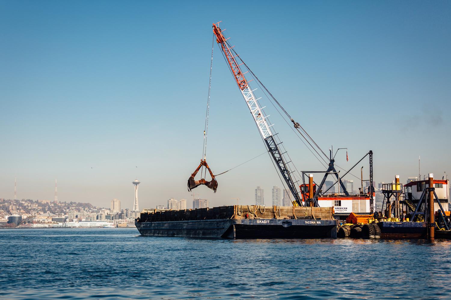 Photo of dredging crane with Seattle skyline